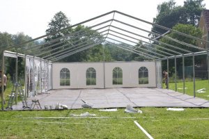 Instalace velkovních plachet na venkovní svatební stan - konstrukce střechy pomalu dostává své zastřešení
